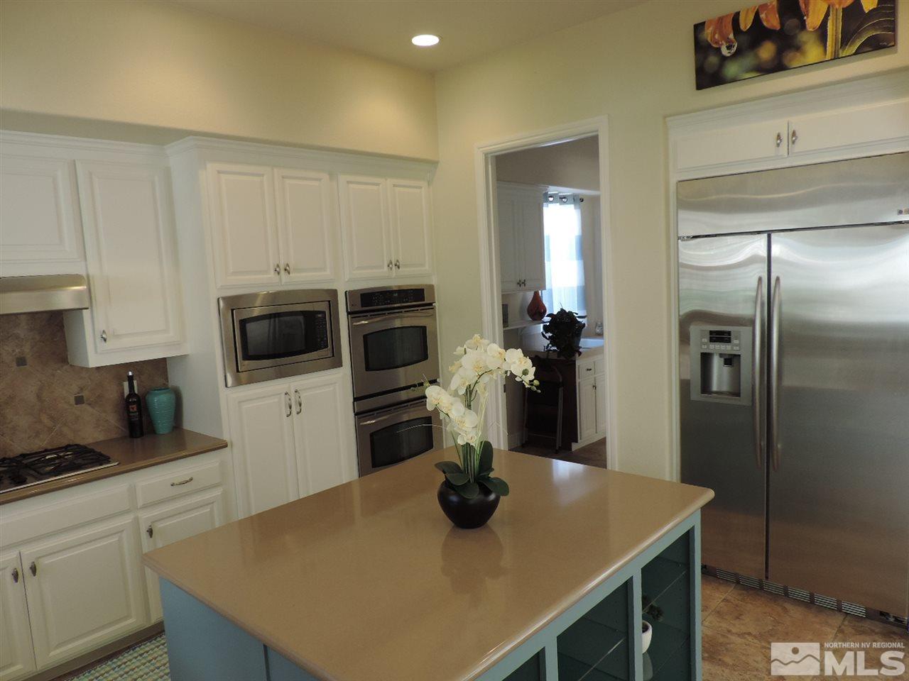 8588 Timaru Trail Reno, NV 89523 - Photo 8 of 25 a kitchen with a sink a refrigerator and microwave