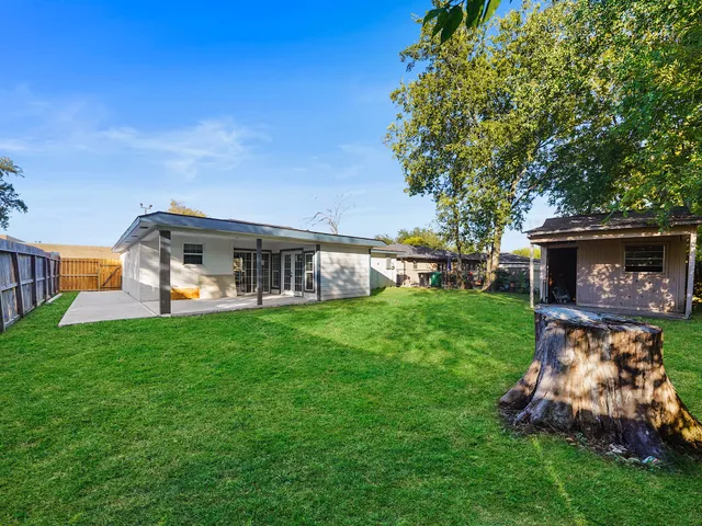 a living room with couches and kitchen view with wooden floor