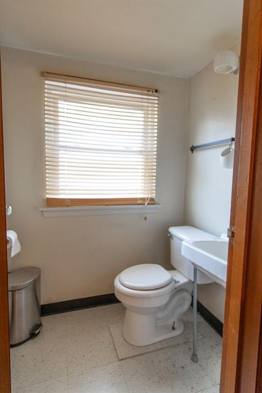935 Howden Street Pittsburgh, PA 15202 - Photo 14 of 16 a bathroom with a toilet a sink a mirror and a window