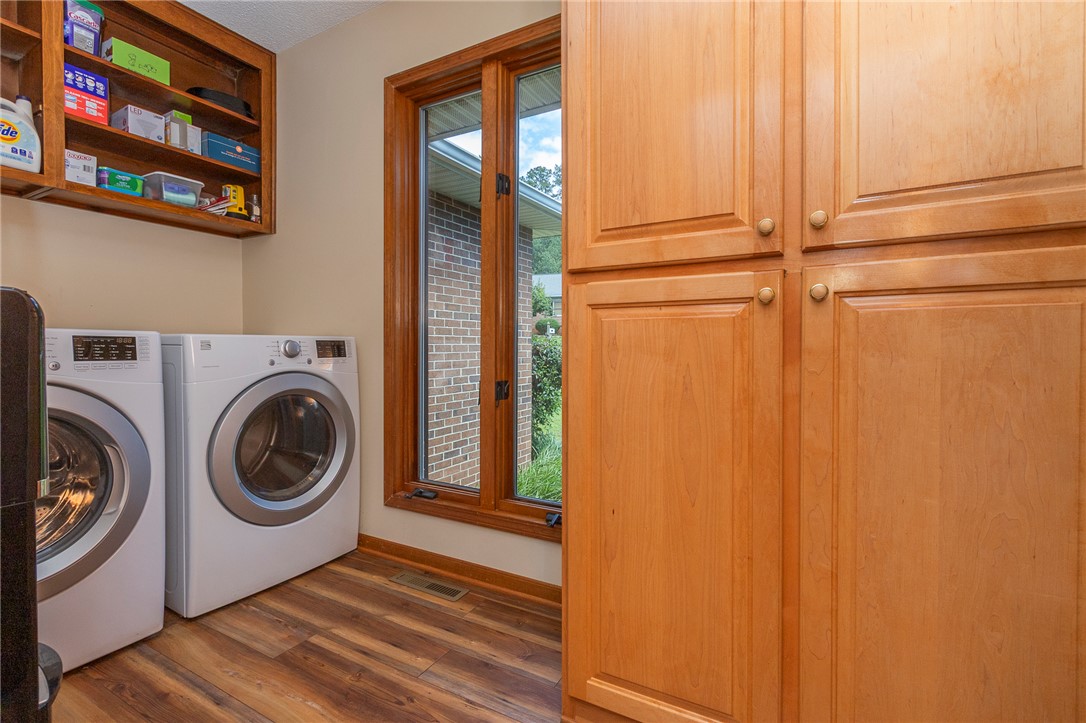 207 Laurel Ridge Road Anderson, SC 29621 - Photo 26 of 50 A dedicated laundry space featuring wood flooring, a window providing natural illumination, and practical cabinetry.