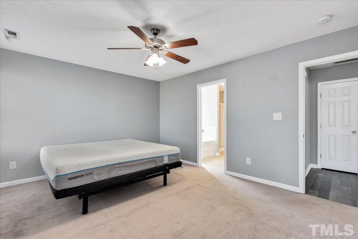549 Cape Fear Road Raeford, NC 28376 - Photo 18 of 27 a bedroom with a bed and a chandelier
