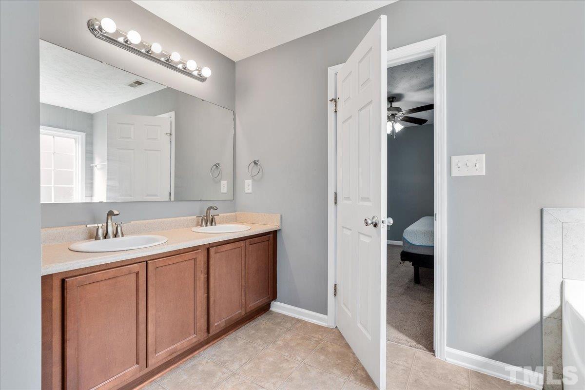 549 Cape Fear Road Raeford, NC 28376 - Photo 19 of 27 a bathroom with a double vanity sink and mirror