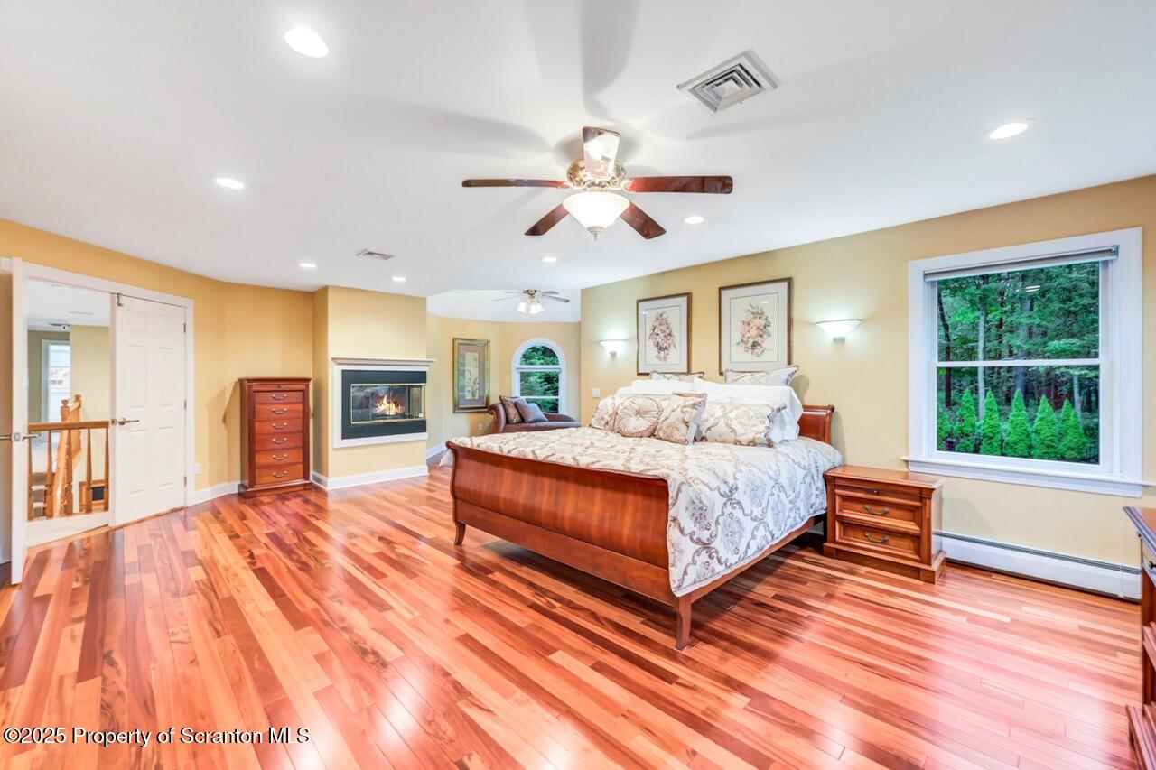 922 Old Logger Road Moscow, PA 18444 - Photo 49 of 93 a spacious bedroom with a large bed a chandelier and windows