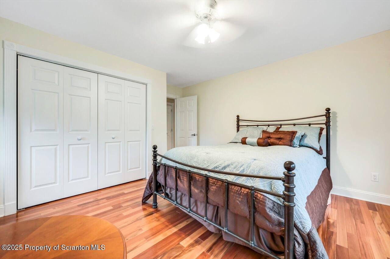 922 Old Logger Road Moscow, PA 18444 - Photo 63 of 93 a bedroom with a bed and a chandelier
