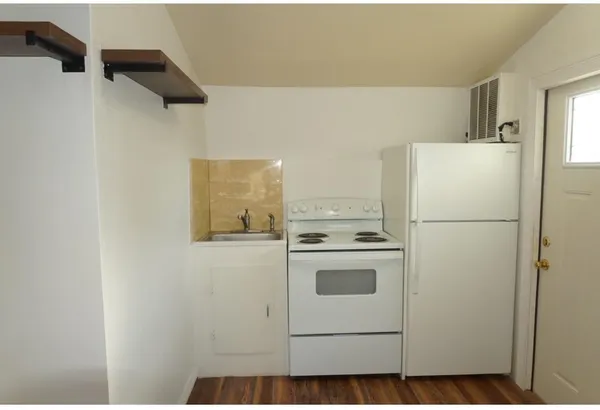a white refrigerator freezer and a stove sitting inside of a kitchen