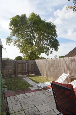 a view of a backyard with a small cabin and wooden fence