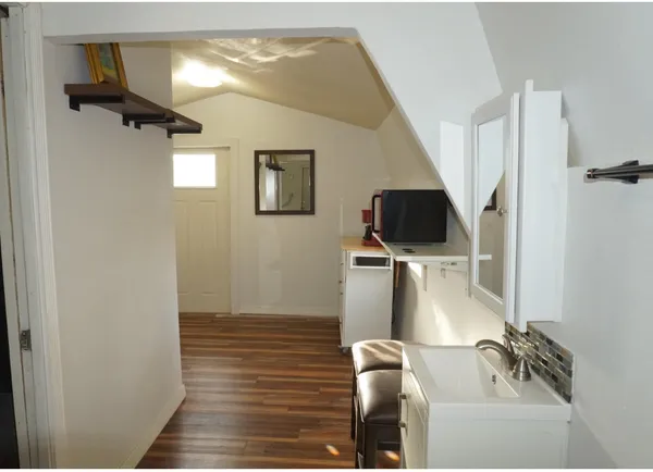 a view of a livingroom with wooden floor and flat screen tv