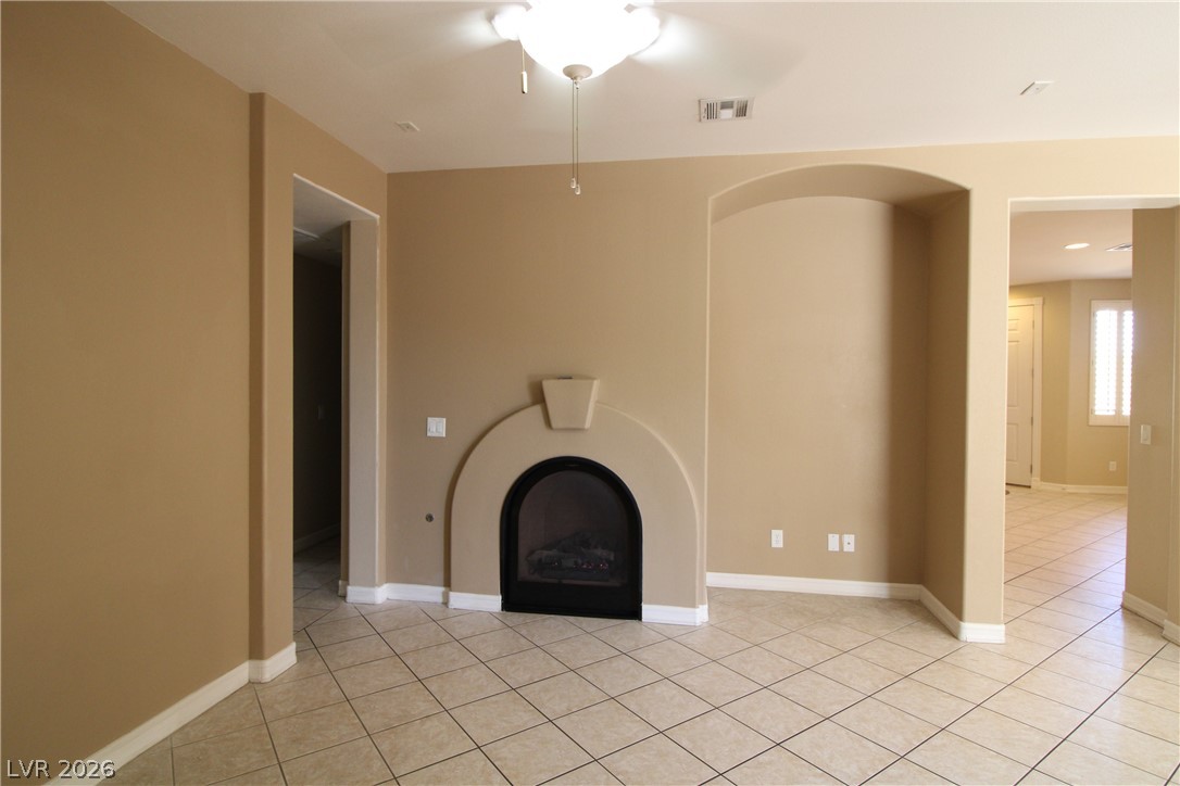 754 Rise Canyon Drive Henderson, NV 89052 - Photo 11 of 34 A living space offers a charming arched fireplace, ready for cozy evenings.