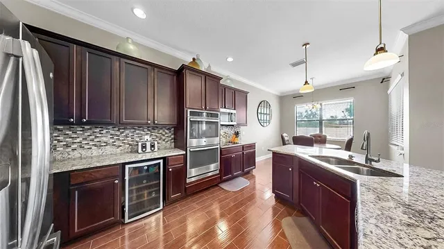 a kitchen with stainless steel appliances granite countertop a sink stove and refrigerator