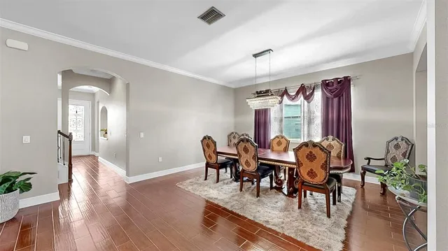 a living room with furniture a chandelier and a flat screen tv