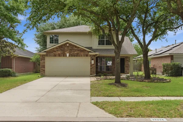 a front view of a house with a yard and trees