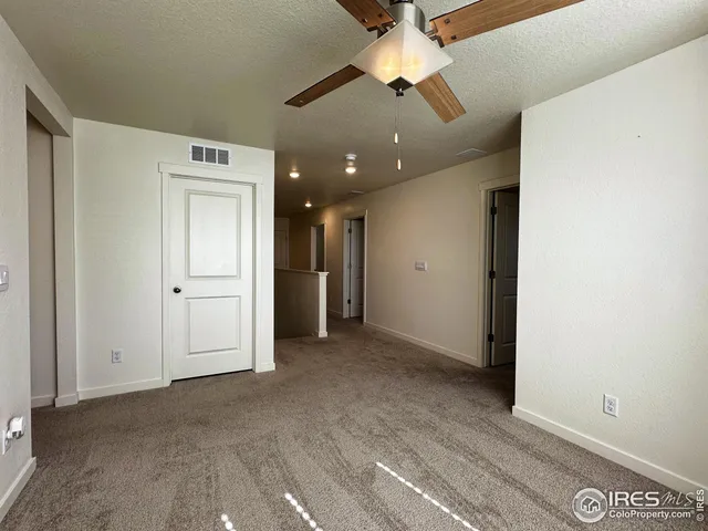 an empty room with a ceiling fan and a window