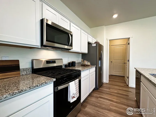 a kitchen with stainless steel appliances granite countertop a stove a refrigerator and a microwave