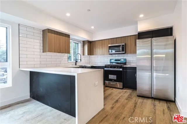 a kitchen with granite countertop stainless steel appliances and wooden cabinets