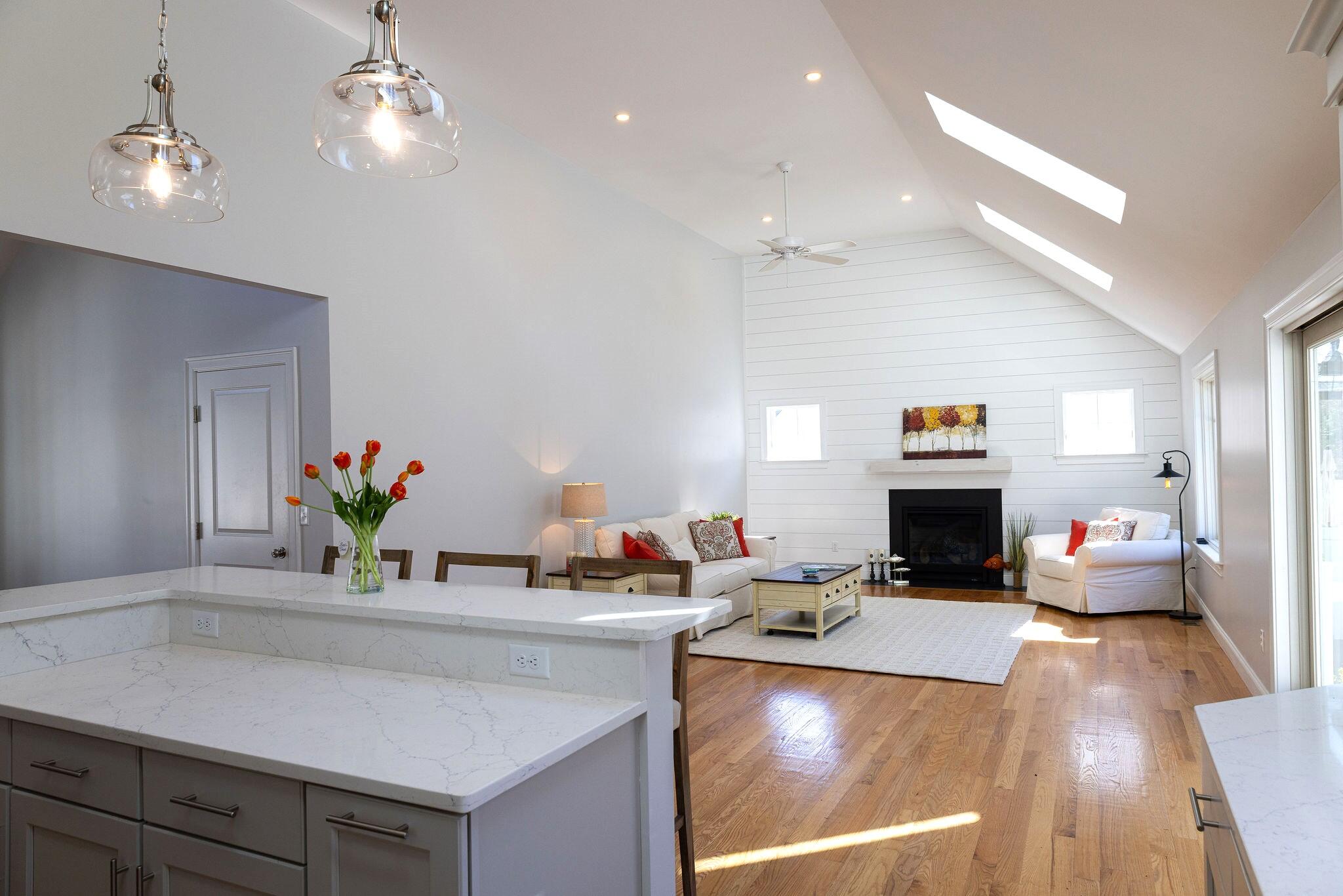 55 Blue Castle Drive Mashpee, MA 02649 - Photo 27 of 52 a living room with kitchen island furniture and a chandelier