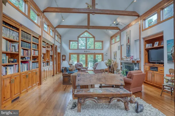 a living room with furniture a chandelier and a floor to ceiling window