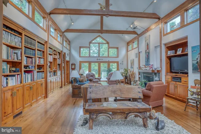 a living room with furniture a chandelier and a floor to ceiling window