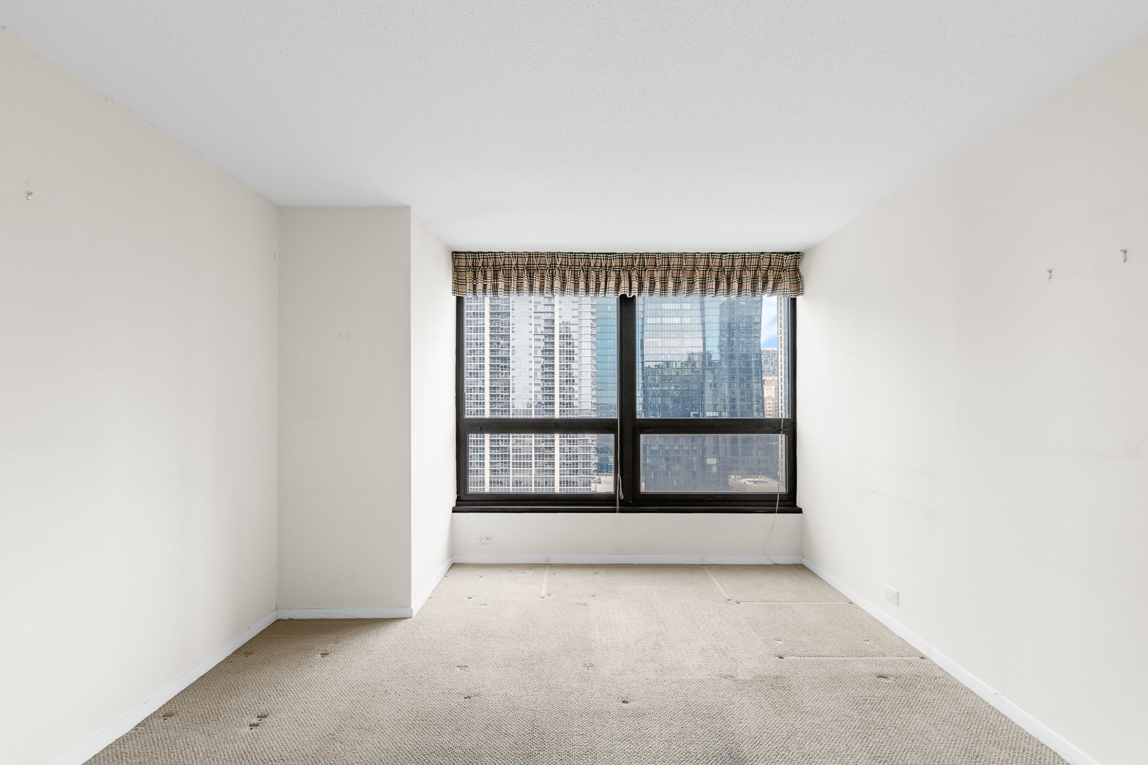 360 East Randolph Street, Unit 2307 Chicago, IL 60601 - Photo 12 of 34 an empty room with wooden floor and windows
