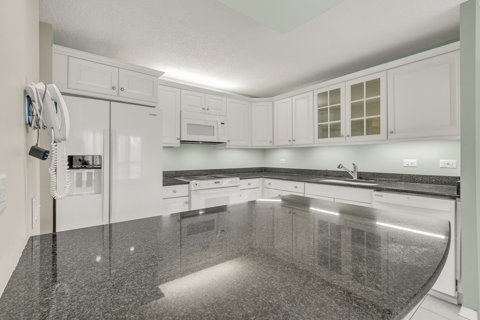 360 East Randolph Street, Unit 2307 Chicago, IL 60601 - Photo 7 of 34 a kitchen with stainless steel appliances granite countertop a refrigerator sink and white cabinets