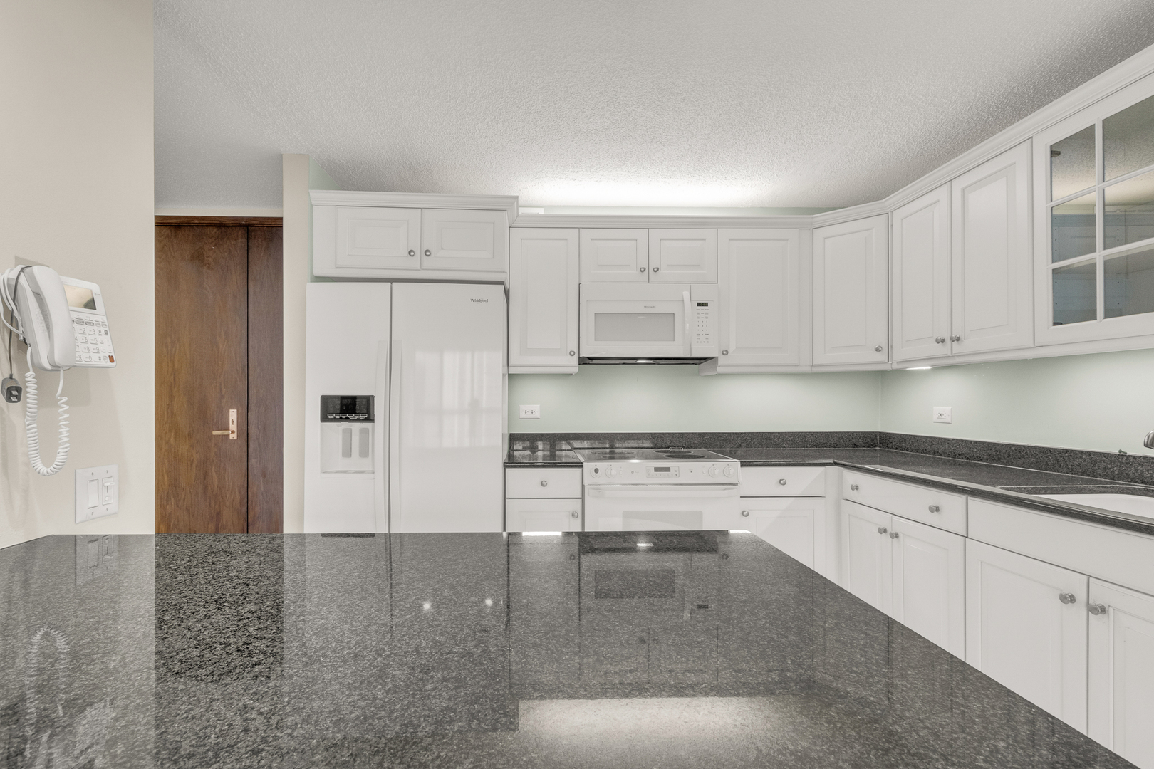 360 East Randolph Street, Unit 2307 Chicago, IL 60601 - Photo 8 of 34 a kitchen with granite countertop white cabinets and stainless steel appliances