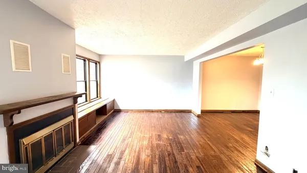 a view of a room with wooden floor and brick walls