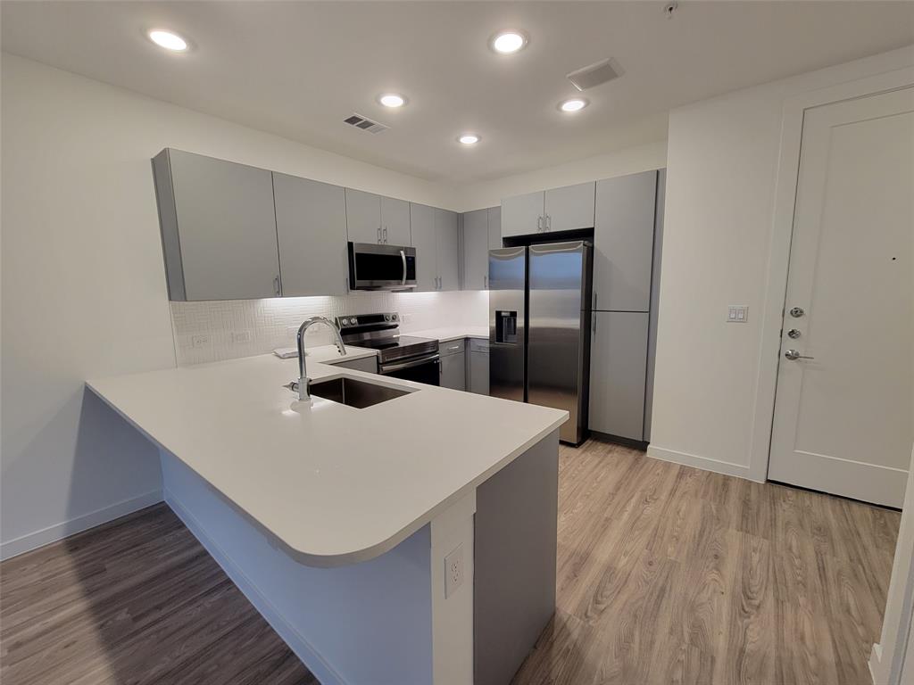4801 Springdale Road, Unit 2211 Austin, TX 78723 - Photo 7 of 19 A well-appointed kitchen showcasing contemporary gray cabinetry and sleek stainless steel appliances.