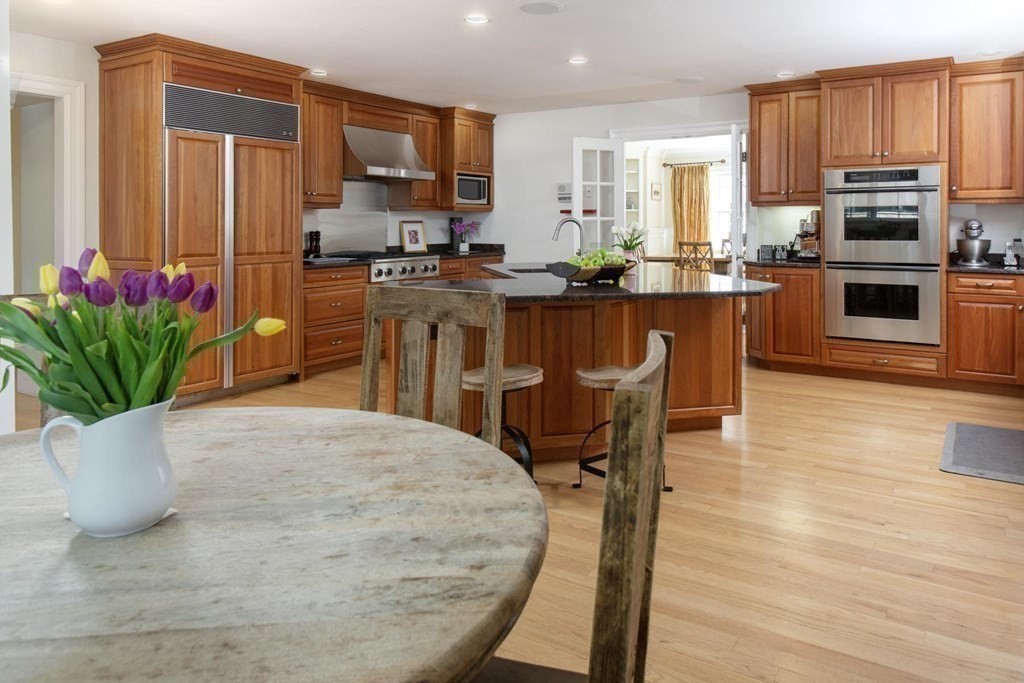 43 Carlton Road Newton, MA 02468 - Photo 7 of 23 a kitchen with stainless steel appliances a dining table chairs and granite counter tops