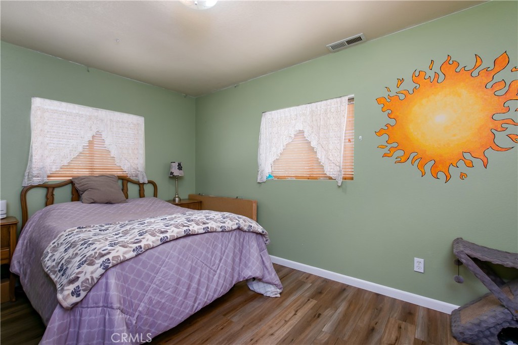 10960 Steinhoff Road Frazier Park, CA 93225 - Photo 33 of 46 The inviting second bedroom located upstairs right next to the hallway bathroom. This versatile room features a clean neutral color palette, white baseboards, and a large window with blinds that fills the space with great natural light, making it a perfect kid's room, guest room, or home office.