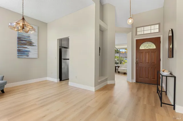 a view of a hallway with wooden floor and a living room