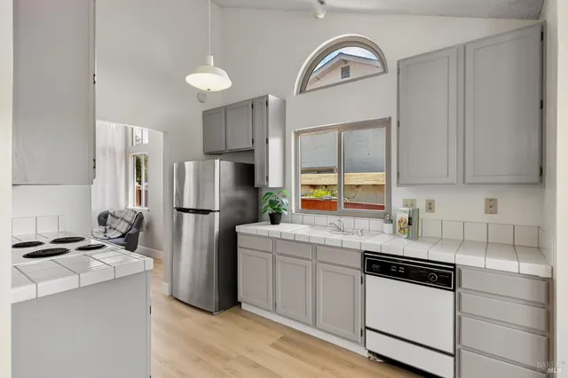 a kitchen with a refrigerator sink and cabinets