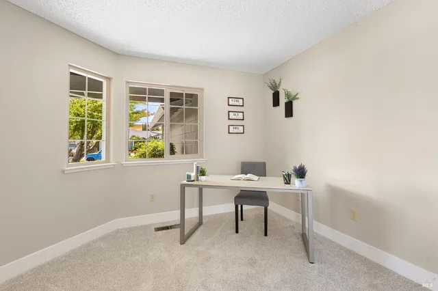 a view of a workspace with furniture and a window