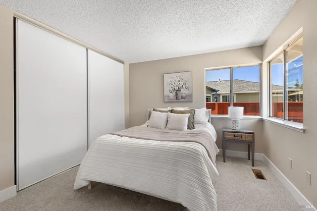 a bedroom with a bed and a large window