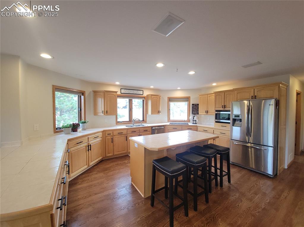 730 Winding Hills Road Monument, CO 80132 - Photo 11 of 42 a kitchen with stainless steel appliances granite countertop a dining table chairs refrigerator and sink