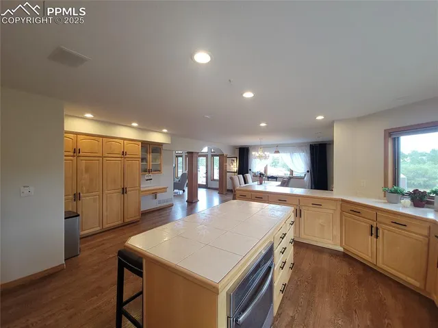 a large kitchen with kitchen island a sink table and chairs