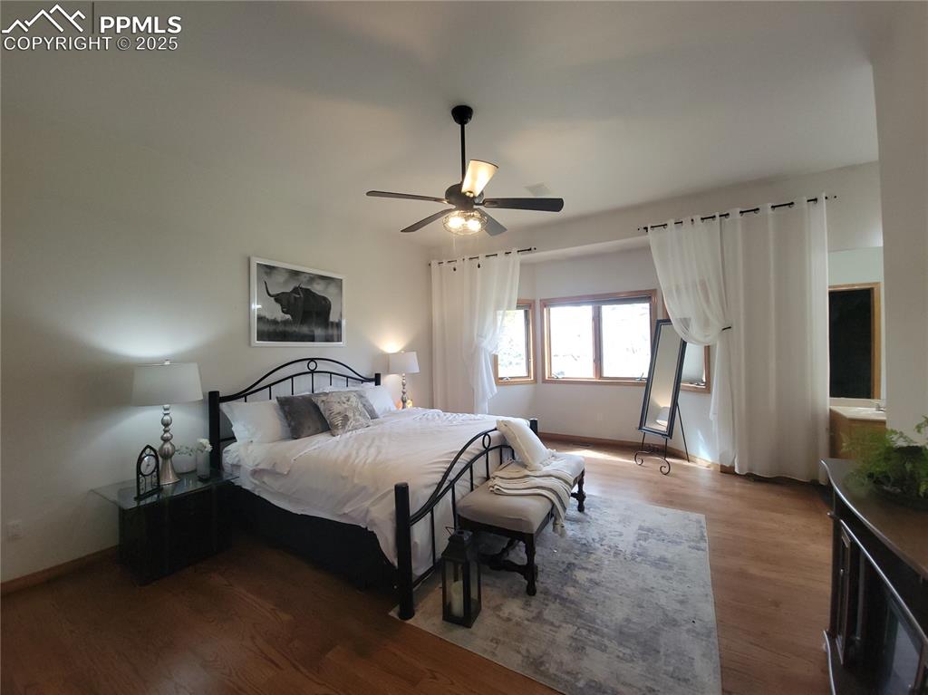 730 Winding Hills Road Monument, CO 80132 - Photo 13 of 42 a bedroom with a bed and a chandelier