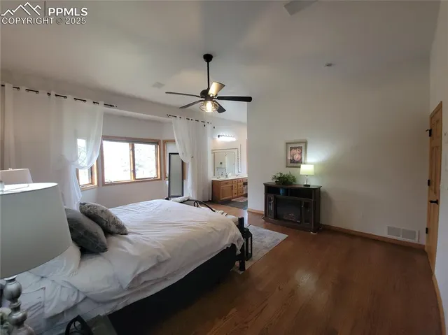 a bedroom with a bed chandelier and a window