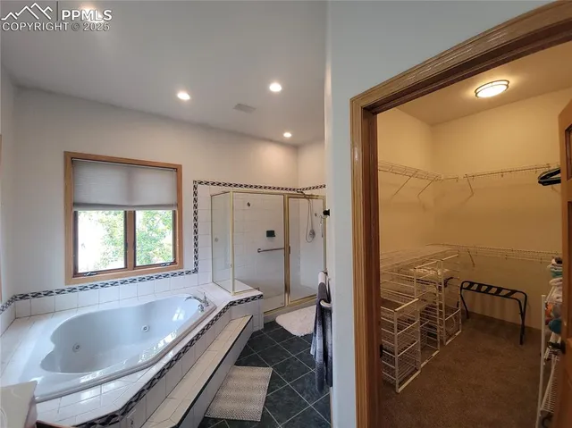 a bathroom with a granite countertop tub mirror and window