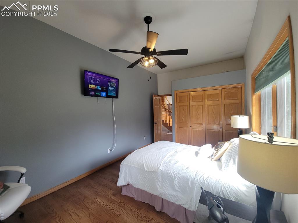 730 Winding Hills Road Monument, CO 80132 - Photo 18 of 42 a bedroom with a bed and a chandelier