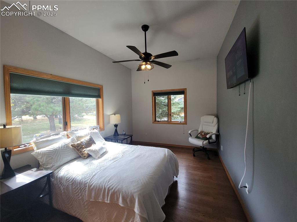 730 Winding Hills Road Monument, CO 80132 - Photo 19 of 42 a bedroom with a bed and a chandelier