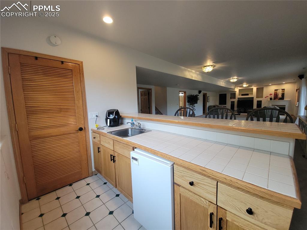 730 Winding Hills Road Monument, CO 80132 - Photo 22 of 42 a kitchen with stainless steel appliances kitchen island granite countertop a refrigerator and a sink