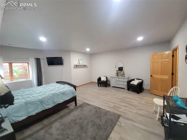 a spacious bedroom with a bed a couch and large window