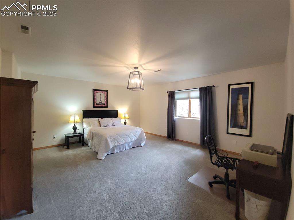 730 Winding Hills Road Monument, CO 80132 - Photo 27 of 42 a bed room with a bed and a lamp