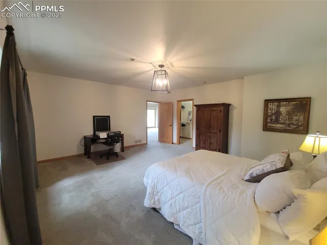 a spacious bedroom with a bed and a chandelier