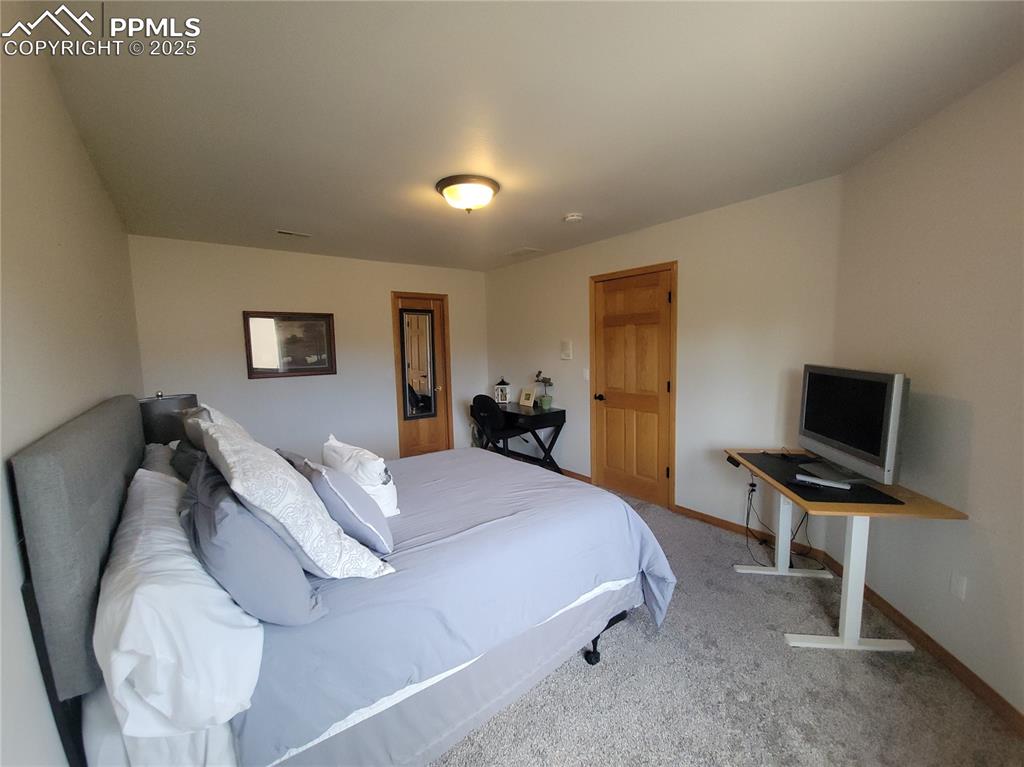 730 Winding Hills Road Monument, CO 80132 - Photo 32 of 42 a bedroom with a bed and a flat screen tv