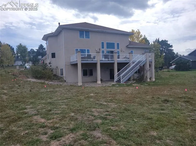 a view of a house with a yard and wooden fence