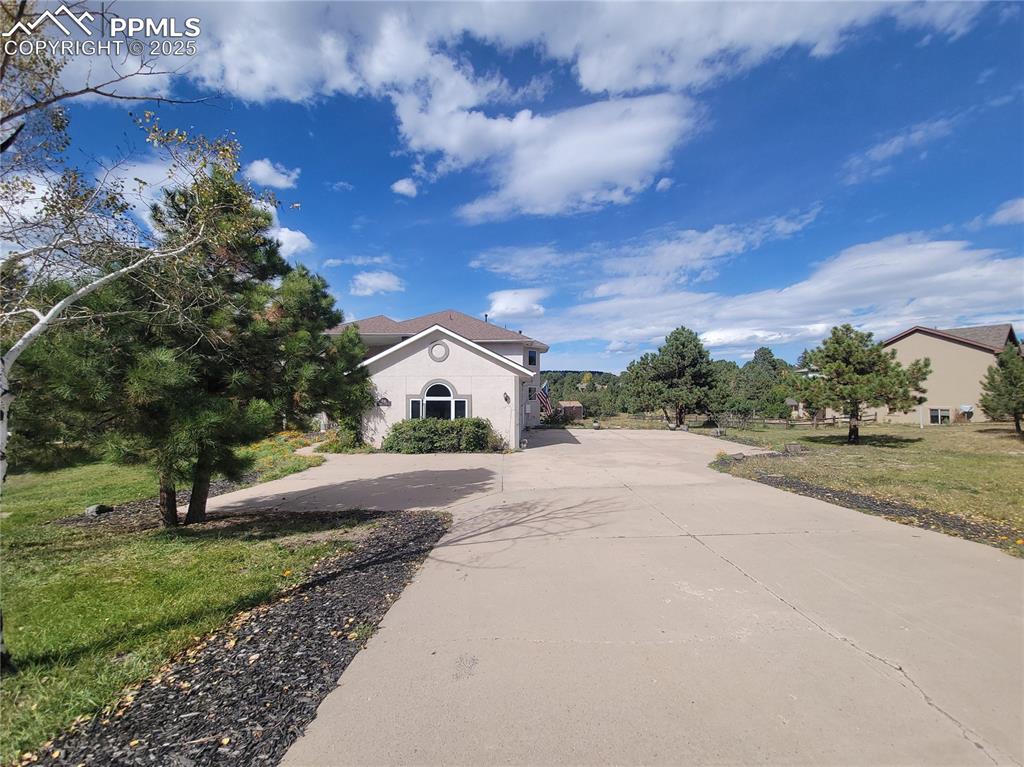 730 Winding Hills Road Monument, CO 80132 - Photo 39 of 42 a front view of a house with a yard and trees