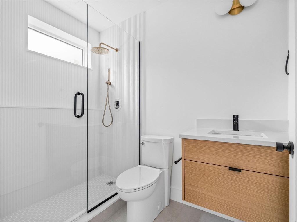 27 Dixwell Street, Unit 1 Boston, MA 02119 - Photo 4 of 13 a bathroom with a granite countertop sink toilet and shower