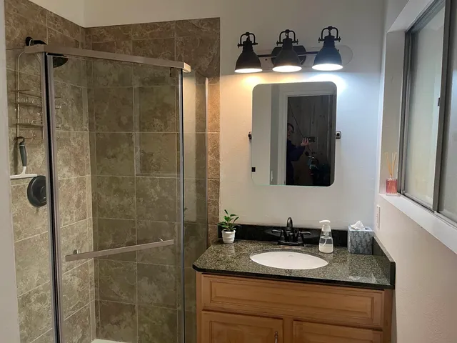 a bathroom with a granite countertop sink and a mirror