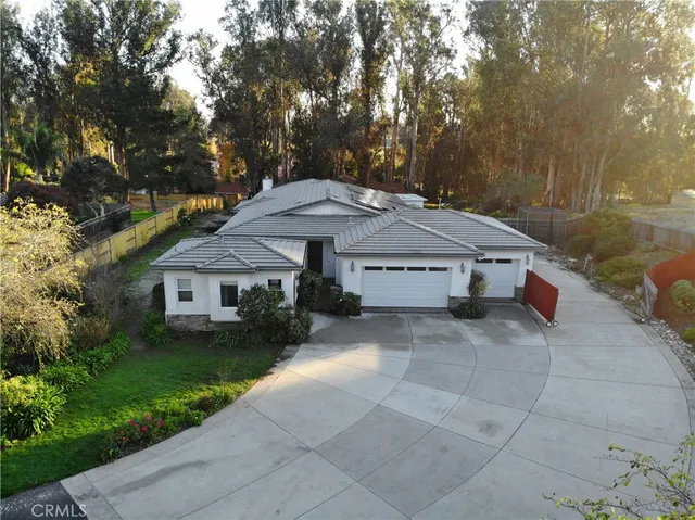 a view of a house with a yard and large tree