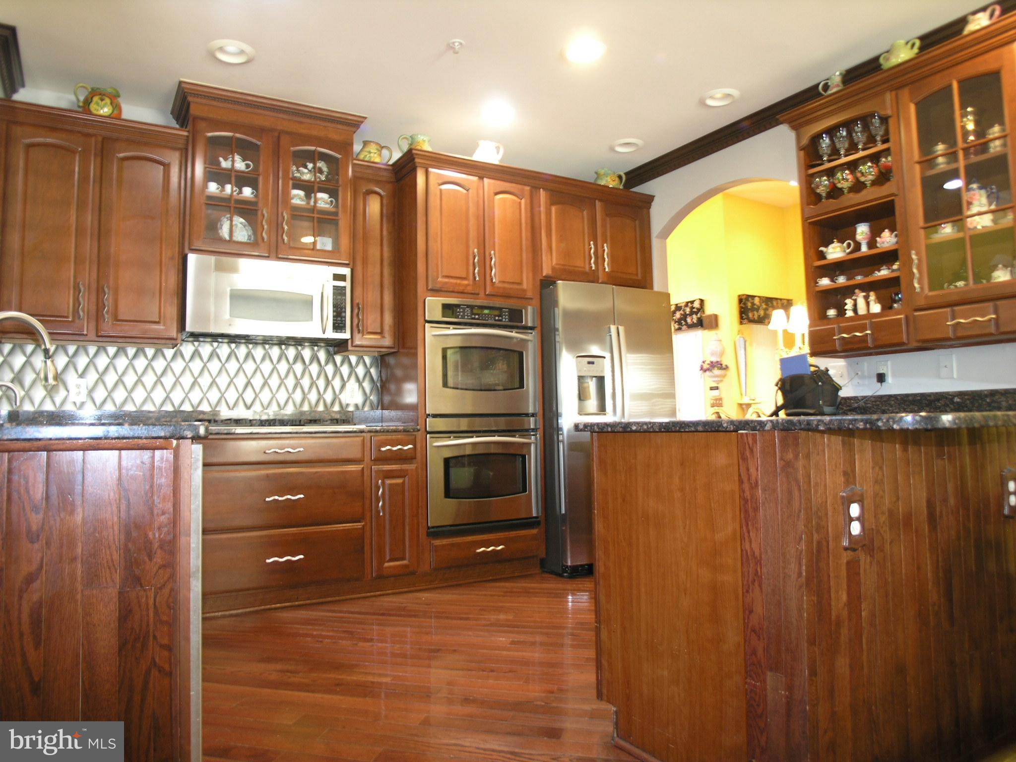 950 Nathaniel Trail Warminster, PA 18974 - Photo 7 of 26 a kitchen with stainless steel appliances granite countertop a refrigerator a stove and a sink with wooden cabinets